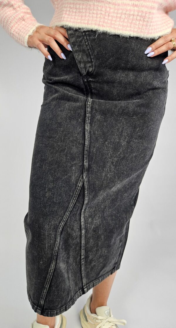 Modna spódnica jeansowa o klasycznym kroju, wyróżniająca się oryginalnym zapięciem z przodu i stylowym rozporkiem, który dodaje swobody ruchów. Wykonana z trwałego denimu, doskonale sprawdzi się w casualowych stylizacjach przez cały rok.