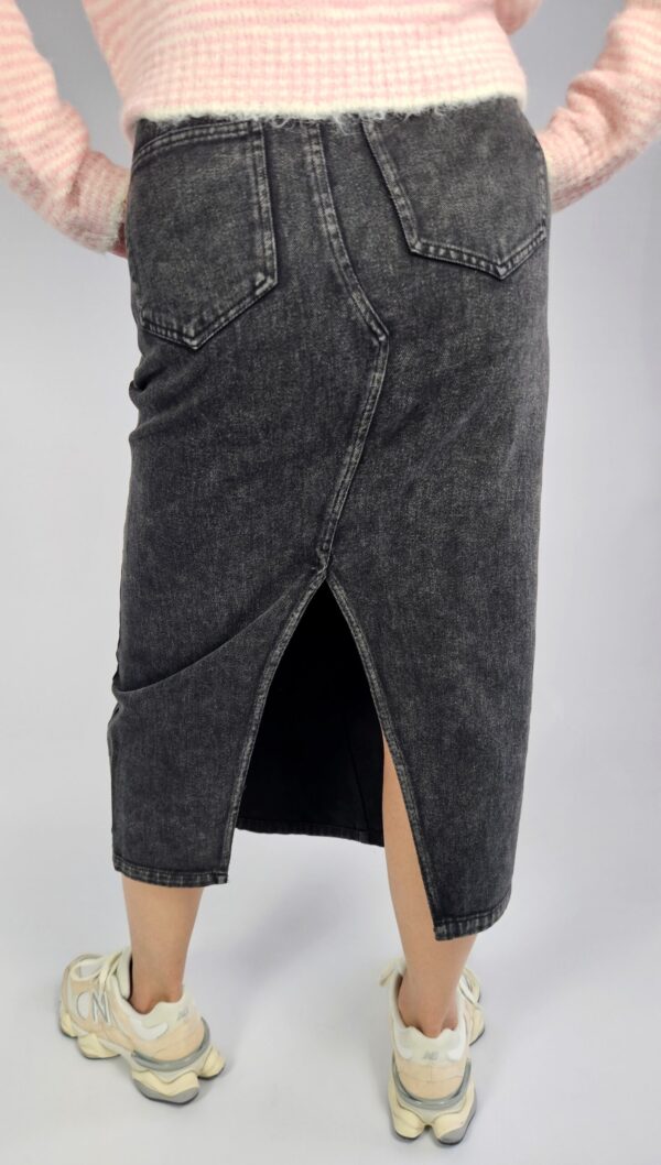 Modna spódnica jeansowa o klasycznym kroju, wyróżniająca się oryginalnym zapięciem z przodu i stylowym rozporkiem, który dodaje swobody ruchów. Wykonana z trwałego denimu, doskonale sprawdzi się w casualowych stylizacjach przez cały rok.