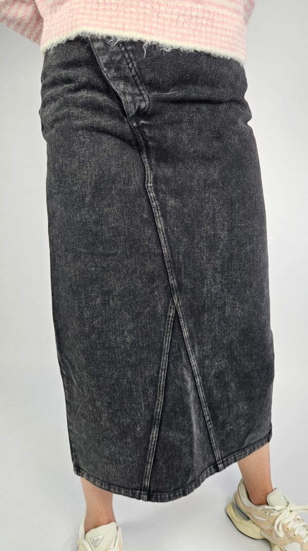 Modna spódnica jeansowa o klasycznym kroju, wyróżniająca się oryginalnym zapięciem z przodu i stylowym rozporkiem, który dodaje swobody ruchów. Wykonana z trwałego denimu, doskonale sprawdzi się w casualowych stylizacjach przez cały rok.