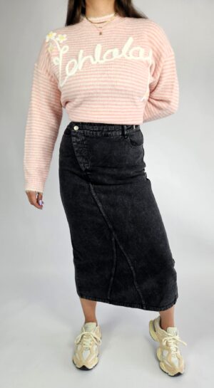 Modna spódnica jeansowa o klasycznym kroju, wyróżniająca się oryginalnym zapięciem z przodu i stylowym rozporkiem, który dodaje swobody ruchów. Wykonana z trwałego denimu, doskonale sprawdzi się w casualowych stylizacjach przez cały rok.