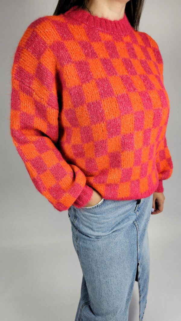 Sweter oversize box Ciepły, miękki sweter w energetycznych odcieniach pomarańczu i różu. Luźny, oversize’owy krój zapewnia swobodę ruchów, a domieszka wełny dodaje mu przytulnego ciepła i komfortu w chłodniejsze dni. Idealny do casualowych, jesienno-zimowych stylizacji