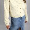 Elegancki i miękki sweter w kolorze kremowym, zapinany na guziki. Wykonany z przyjemnej w dotyku dzianiny z dodatkiem angory, która nadaje mu wyjątkową puszystość i ciepło. Doskonały na chłodniejsze dni – lekki, a jednocześnie otulający.