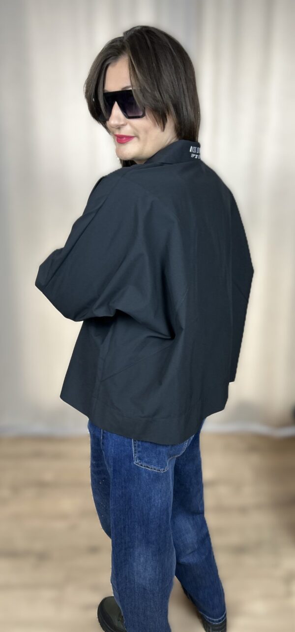 Stylowa, krótka koszula zapinana na guziki, z długim rękawem zakończonym mankietem. Na piersi dwie kieszenie z klapami, z których jedna ozdobiona jest subtelnym, wyszywanym serduszkiem. Idealna do nowoczesnych, codziennych i lekko romantycznych stylizacji.