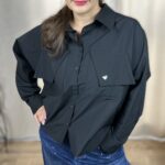 koszula czarna heart Stylowa, krótka koszula zapinana na guziki, z długim rękawem zakończonym mankietem. Na piersi dwie kieszenie z klapami, z których jedna ozdobiona jest subtelnym, wyszywanym serduszkiem. Idealna do nowoczesnych, codziennych i lekko romantycznych stylizacji.