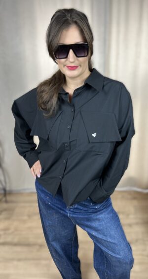 Stylowa, krótka koszula zapinana na guziki, z długim rękawem zakończonym mankietem. Na piersi dwie kieszenie z klapami, z których jedna ozdobiona jest subtelnym, wyszywanym serduszkiem. Idealna do nowoczesnych, codziennych i lekko romantycznych stylizacji.